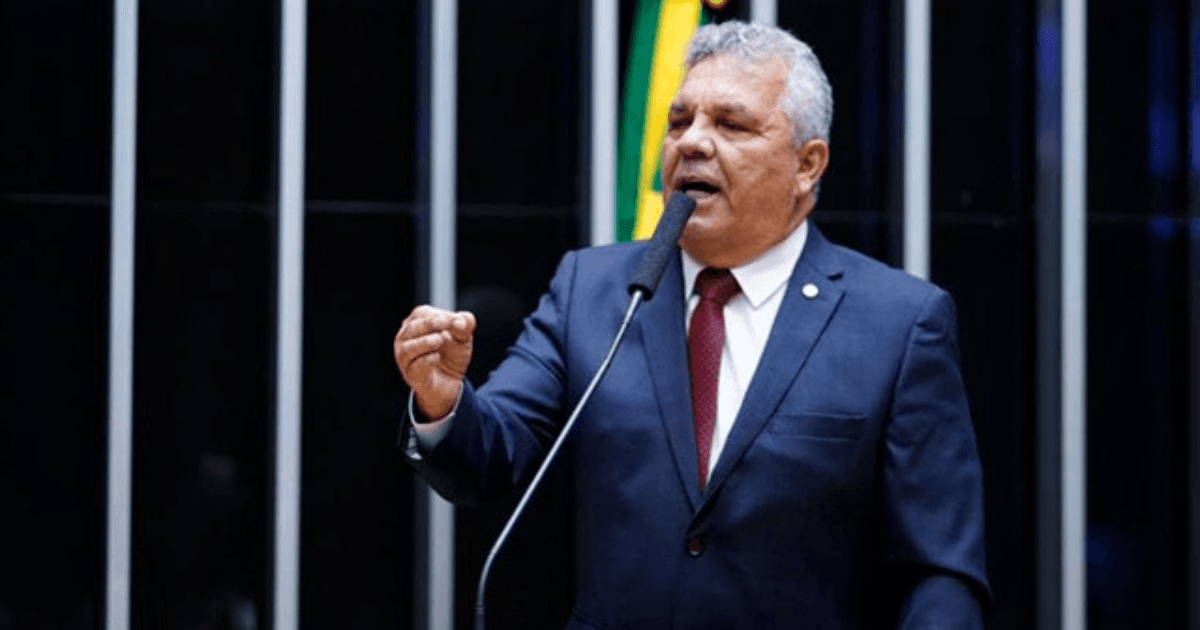 Deputado Alberto Fraga discursa em plenário com a bandeira do Brasil ao fundo.