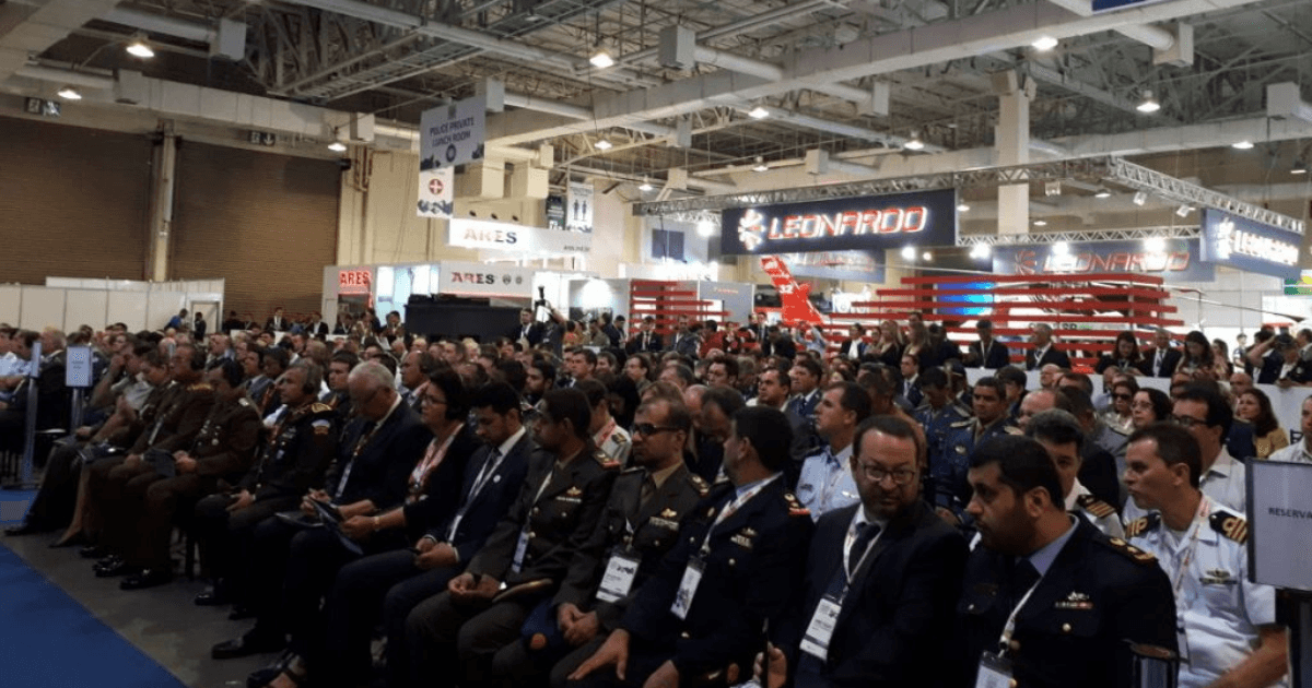 Auditório lotado durante uma feira internacional de segurança e defesa.