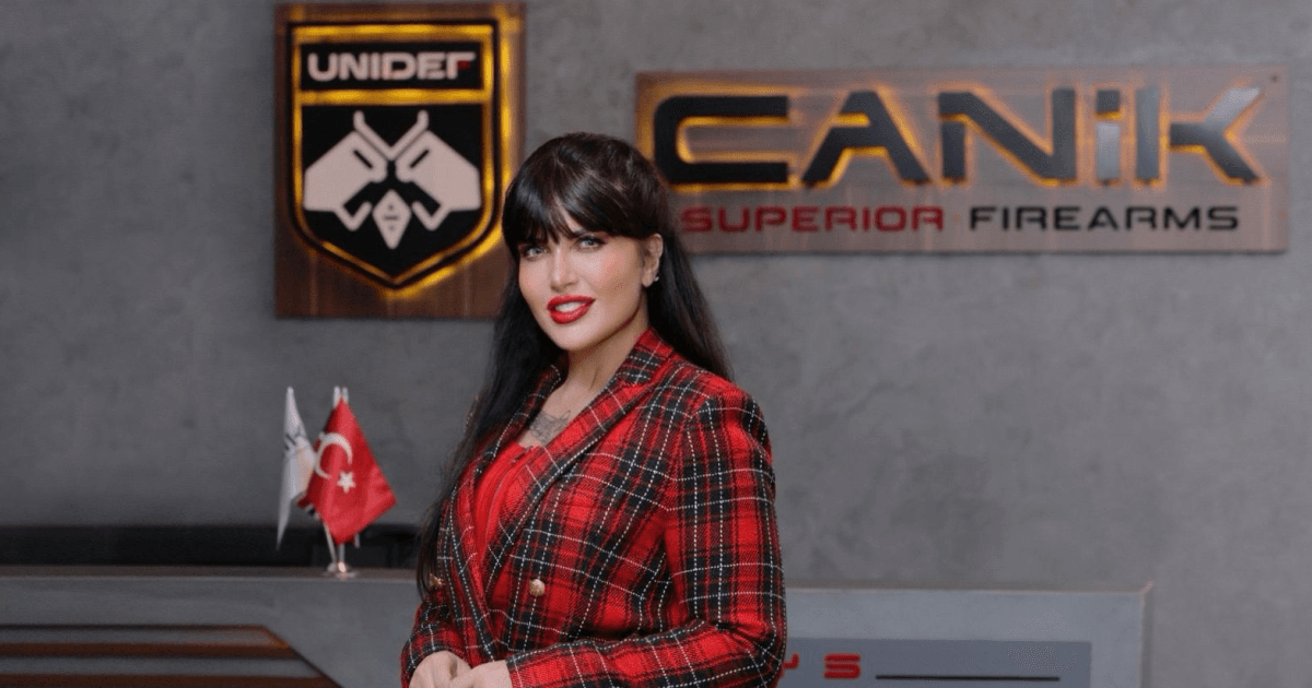 Mulher posa diante dos logotipos da Canik e da Unidef na Turquia.
