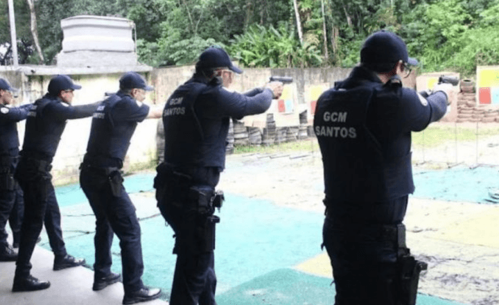 Guardas municipais de Santos praticam tiro em um estande ao ar livre.