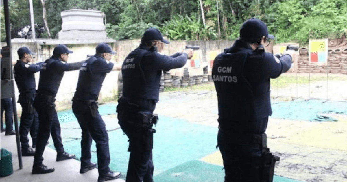 Guardas municipais de Santos praticam tiro em um estande ao ar livre.