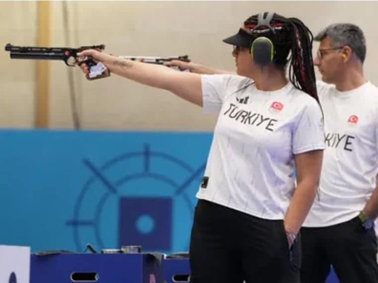 Atleta turca aponta uma pistola durante prova de tiro esportivo.