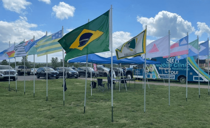 Bandeiras de vários países alinhadas em área externa de competição de tiro.