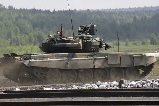 Tanque militar percorre terreno aberto durante exercício.