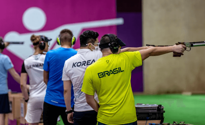 Atleta brasileiro compete com pistola em uma prova internacional de tiro esportivo.