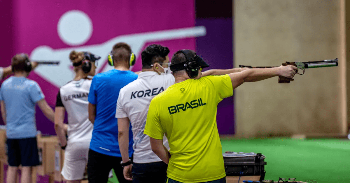 Atleta brasileiro compete com pistola em uma prova internacional de tiro esportivo.