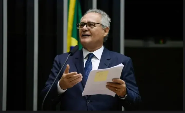 Senador discursa no plenário segurando documentos.