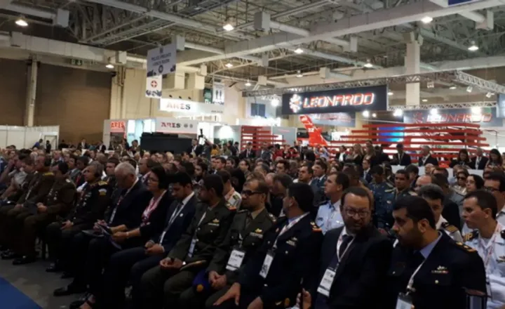 Auditório lotado durante feira de segurança e defesa.