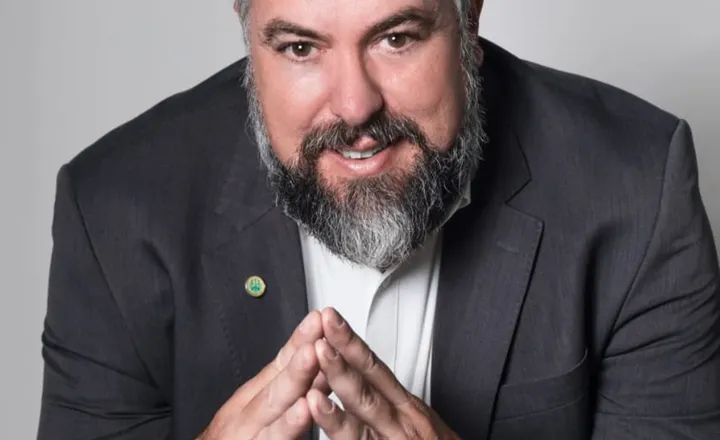 Retrato de advogado de terno em fundo cinza.
