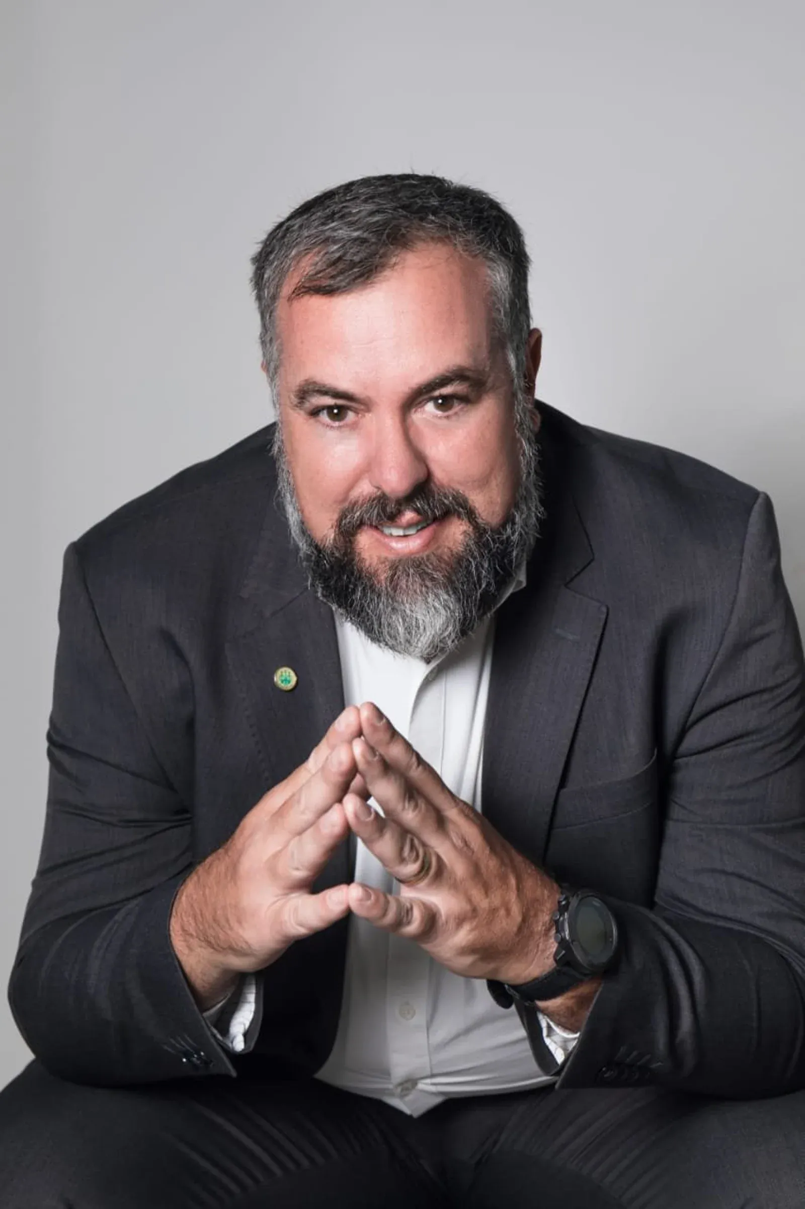 Retrato de advogado de terno em fundo cinza.