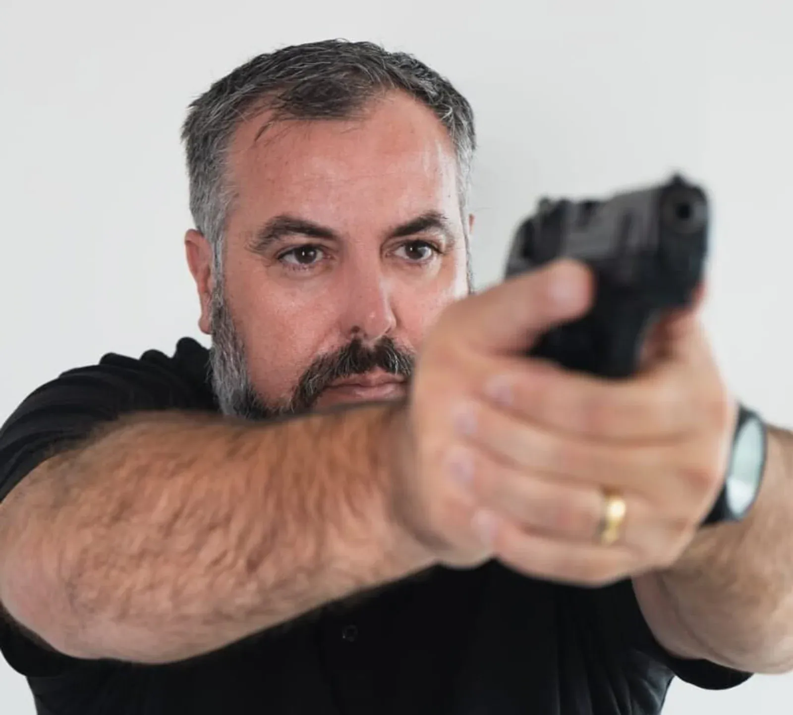 Homem demonstra equipamento de visão segurando uma pistola.