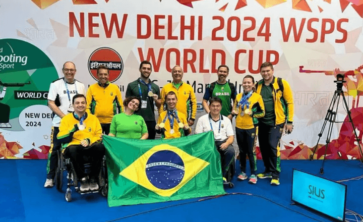Delegação brasileira exibe medalhas e a bandeira nacional na Copa do Mundo de tiro.