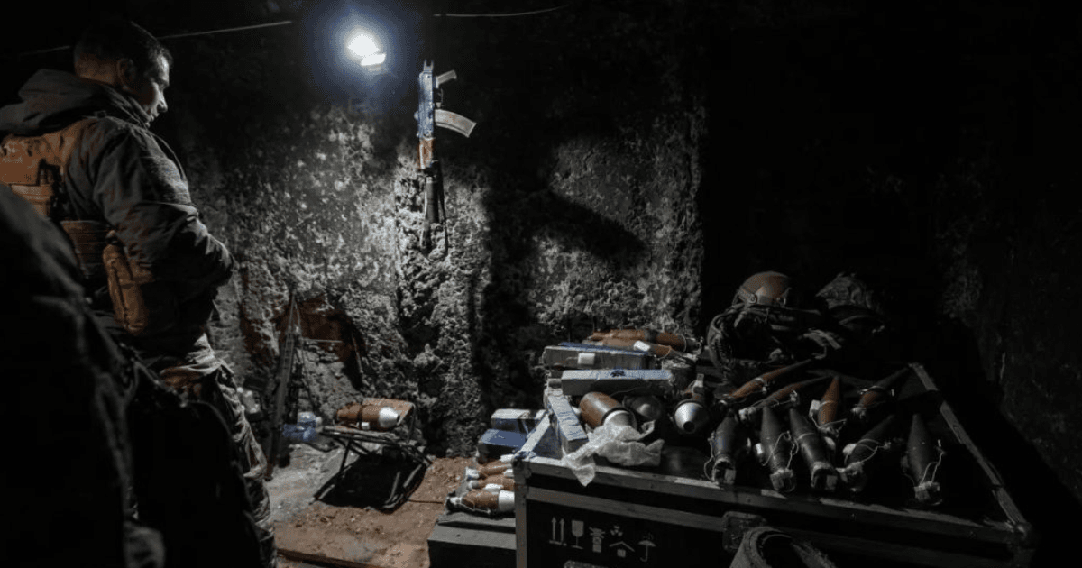 Militares trabalham com armamentos em uma posição escura de combate.
